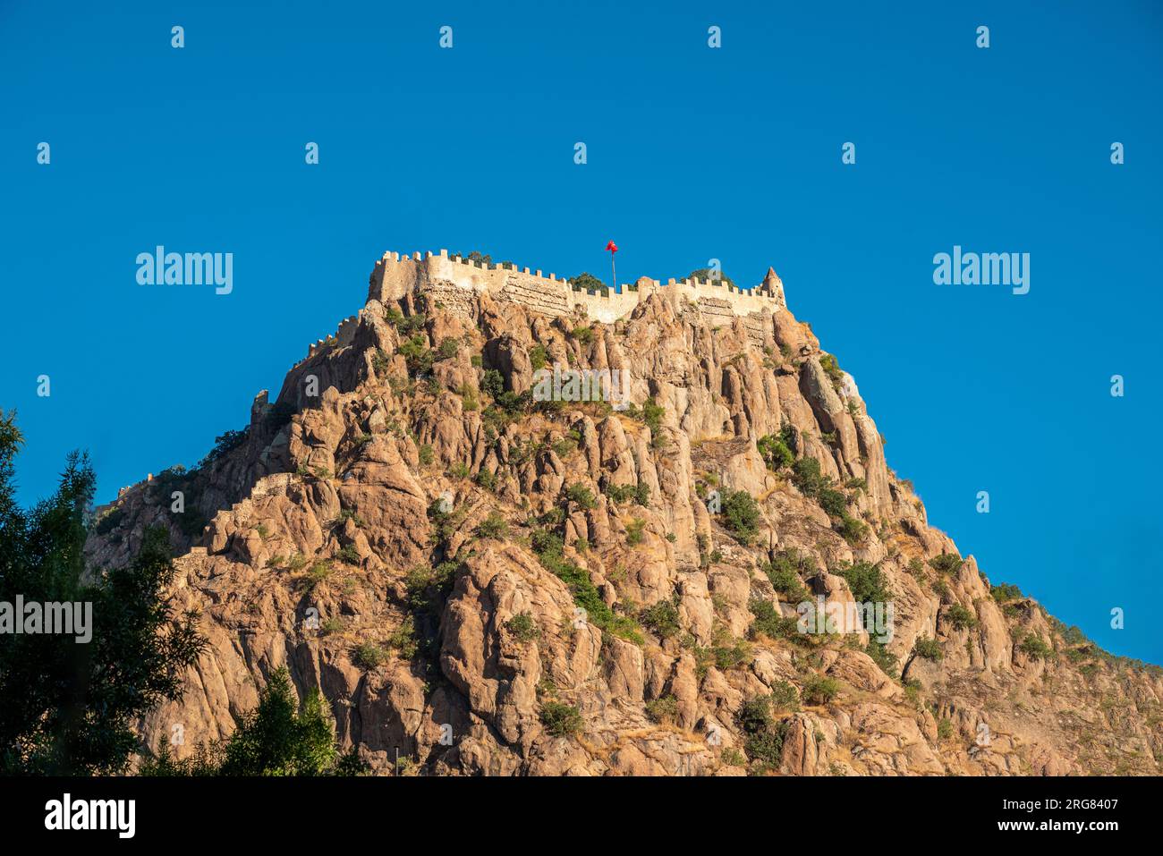 Afyon castle on the rock in Afyonkarahisar Turkey in front of a sunny blue sky Stock Photo