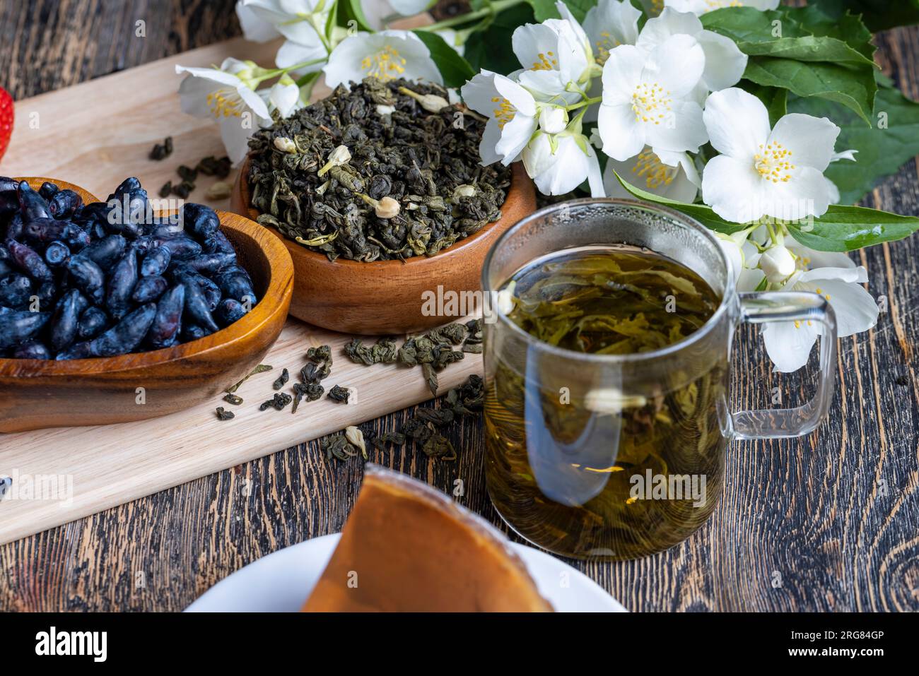 Brewed green tea with jasmine on the table, dried tea leaf for brewing
