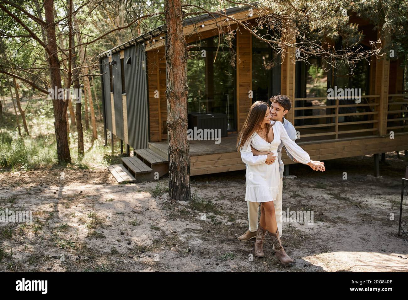 happiness and laughter, man hugging woman near vacation house, in ...