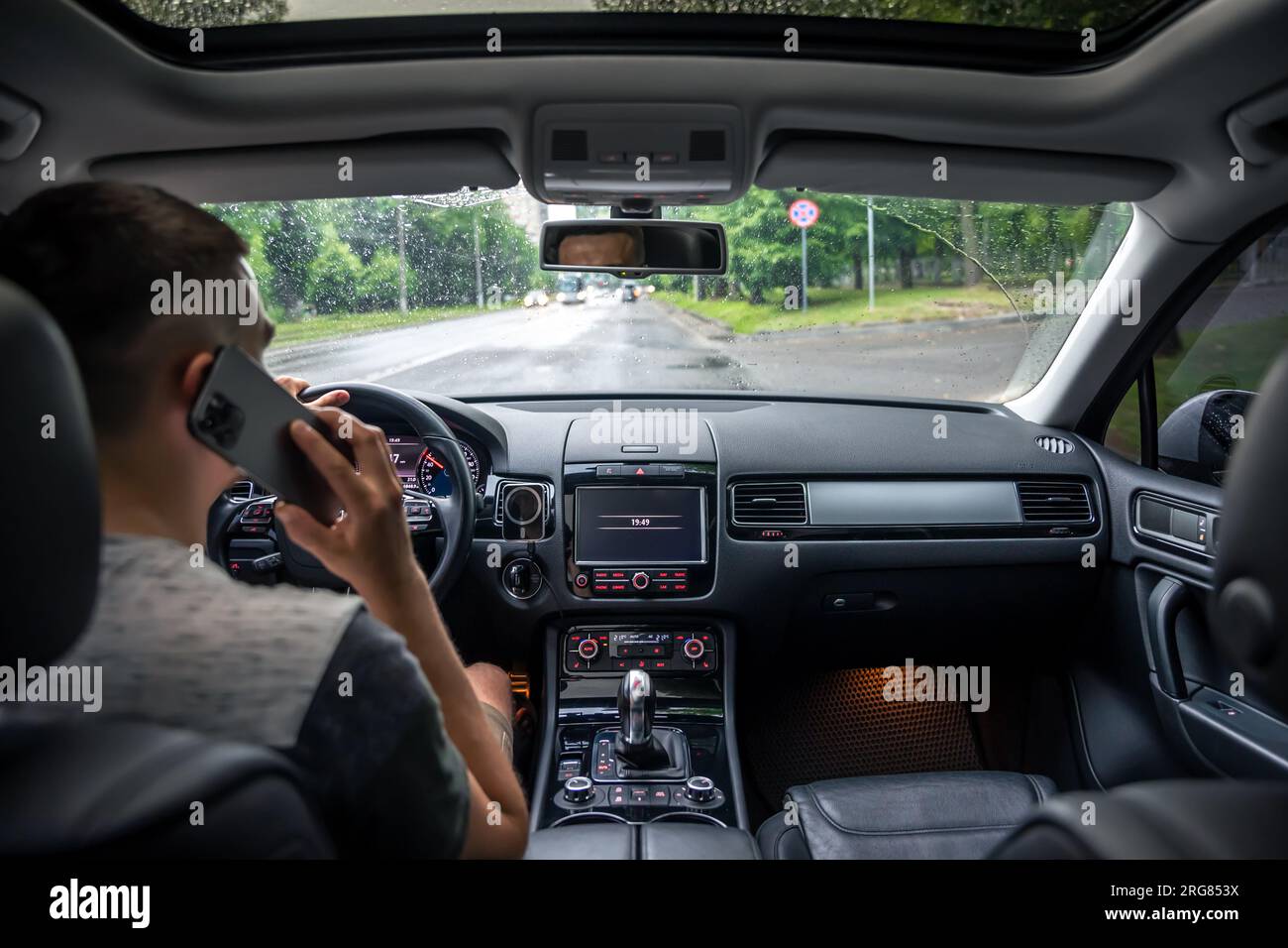 Businessman talking on cell phone while driving. Stock Photo