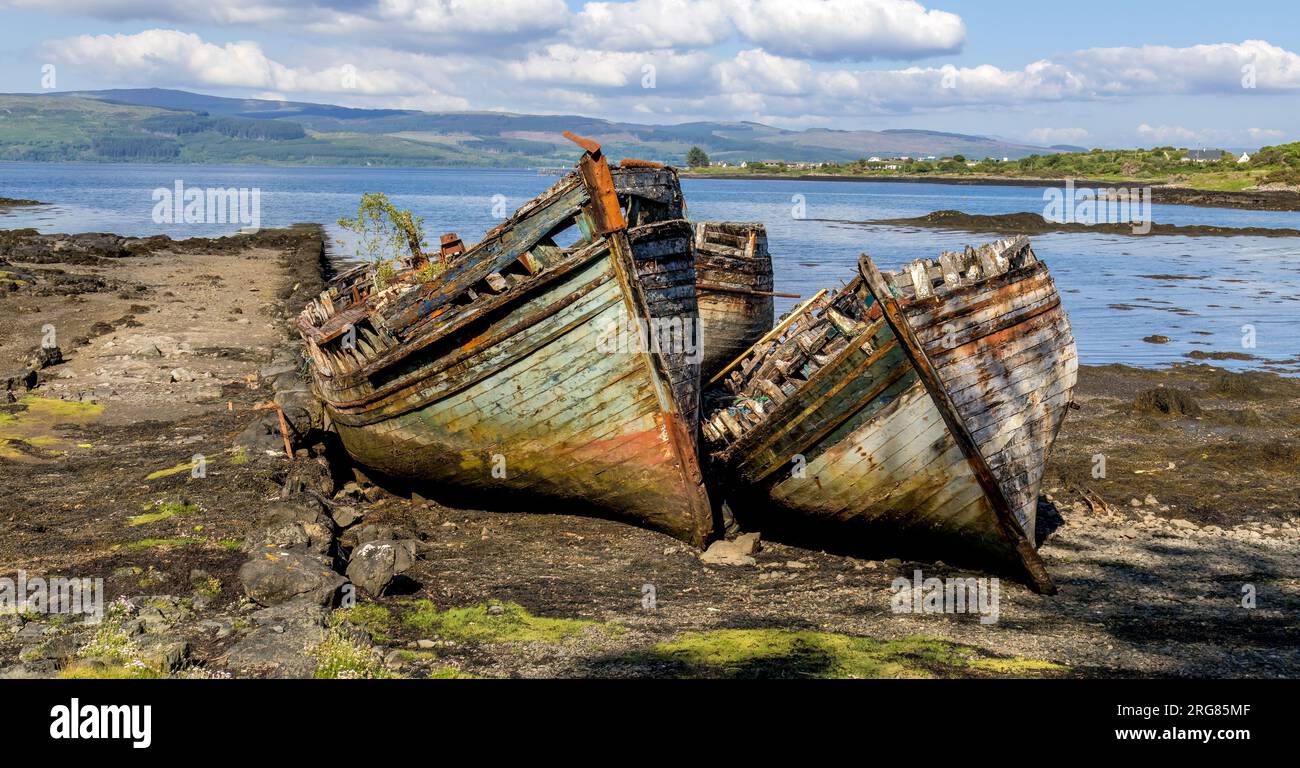 Old wooden fishing boats wrecked at the side of the sea, Isle of Mull ...