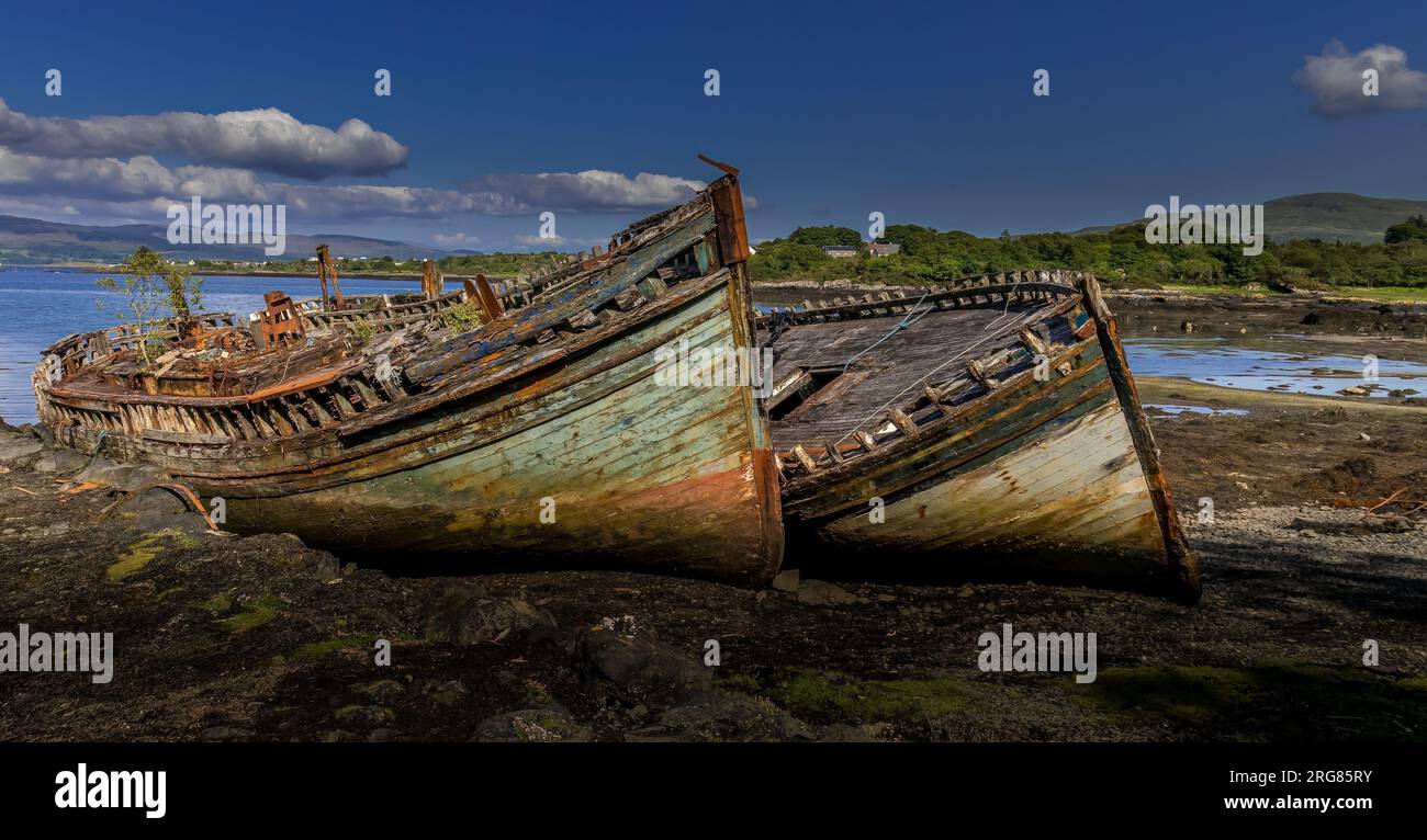 Old wooden fishing boats wrecked at the side of the sea, Isle of Mull ...
