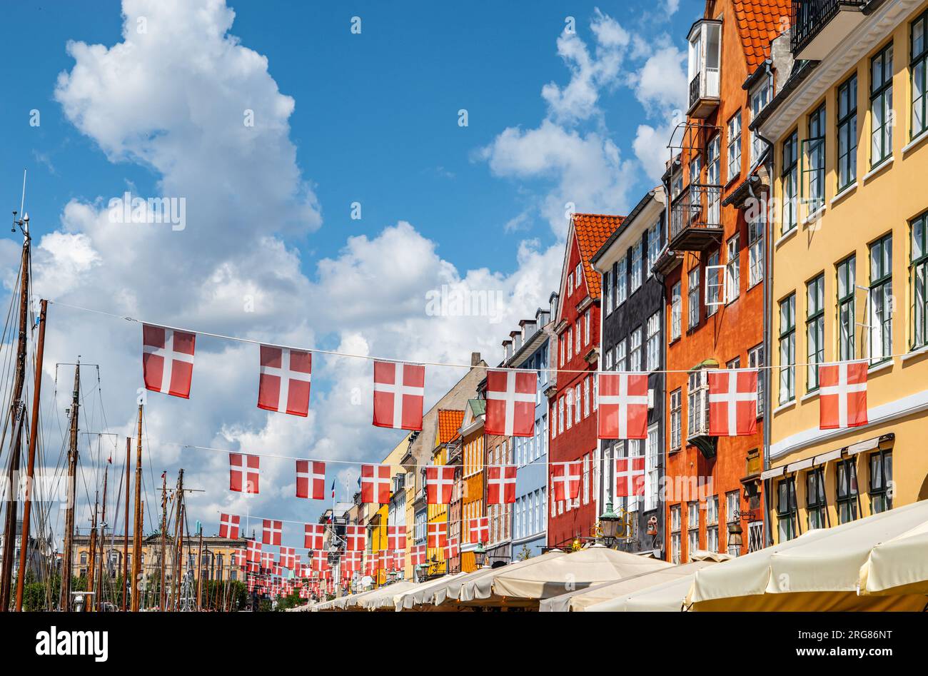 Danish flags and colorful buildings in Nyhavn, Copenhagen in Denmark. Stock Photo