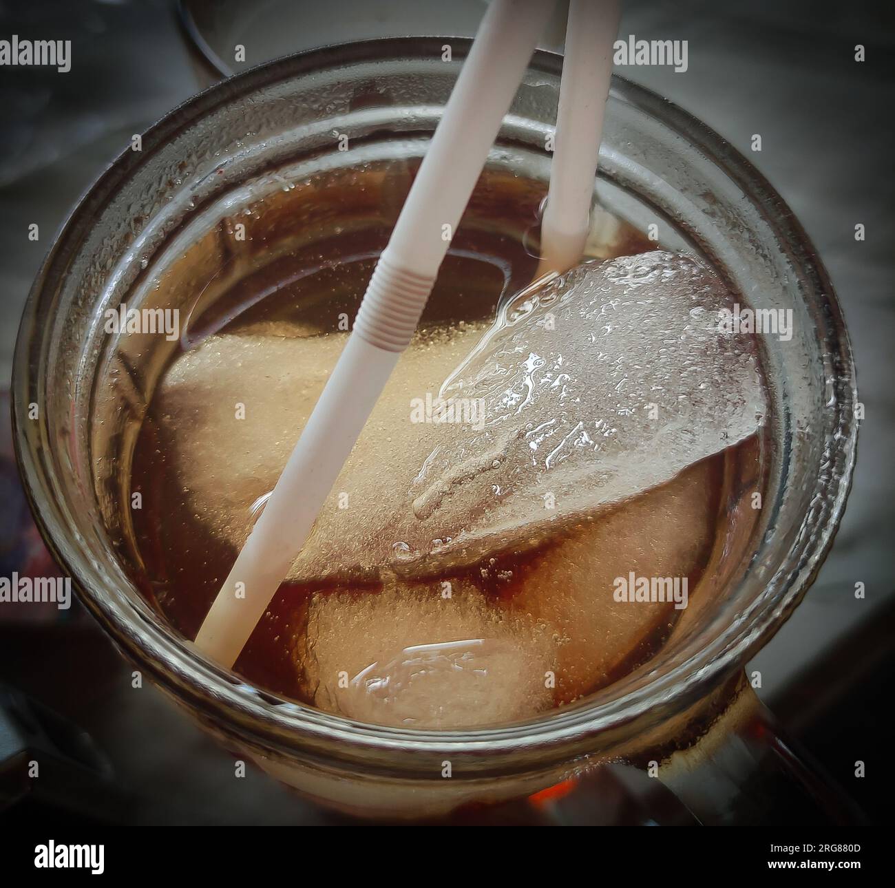 https://c8.alamy.com/comp/2RG880D/close-up-of-iced-tea-and-ice-cubes-in-a-glass-cup-with-a-plastic-straw-2RG880D.jpg