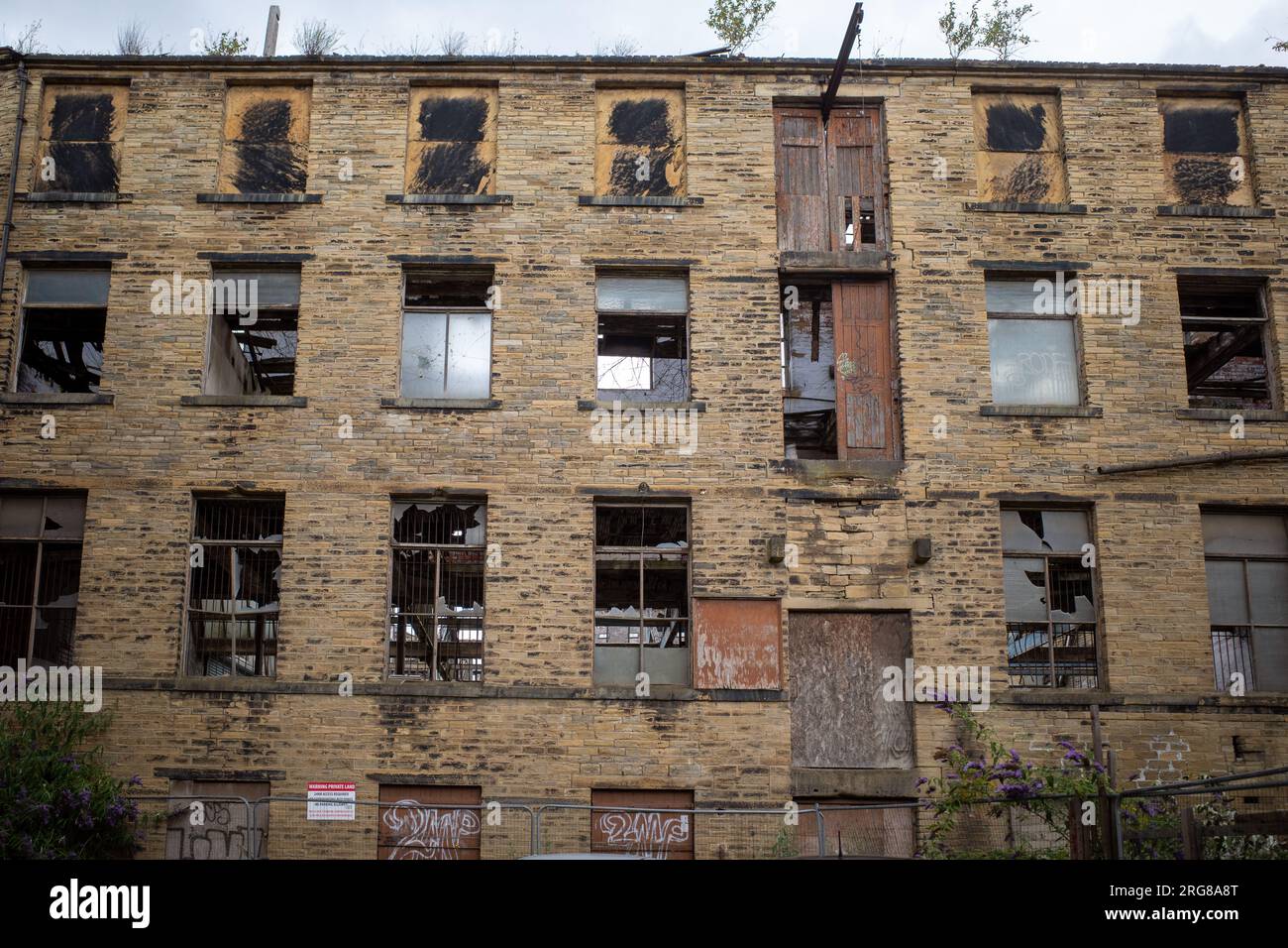 Facade of old derelict factory with broken windows in the back streets of Bradford, Yorkshire, England, UK. 2023 Stock Photo