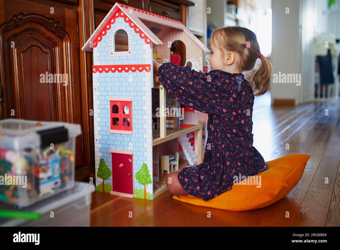 adorable-preschooler-girl-having-fun-with-doll-house-in-playroom-at