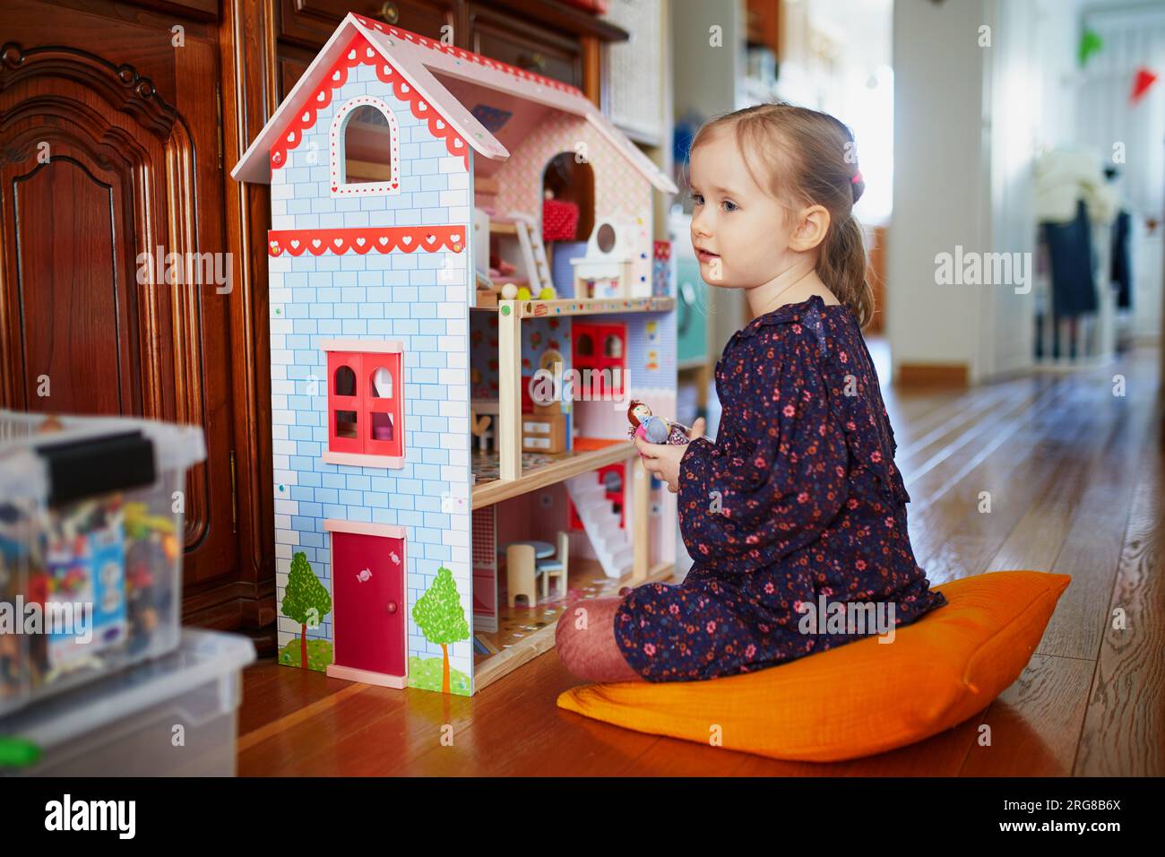 adorable-preschooler-girl-having-fun-with-doll-house-in-playroom-at