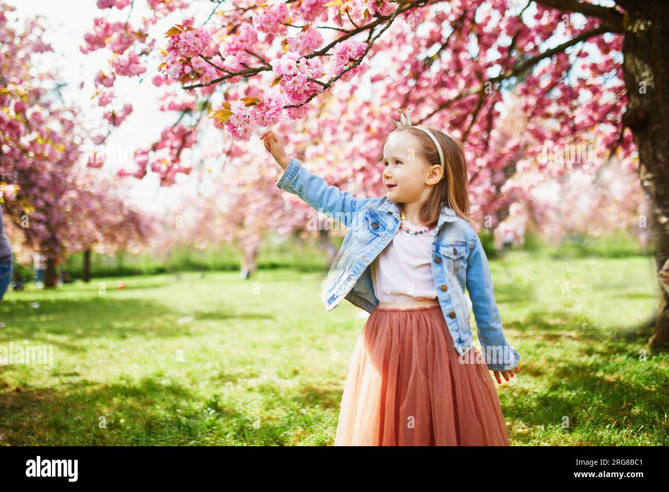 Adorable preschooler girl in tutu skirt enjoying nice spring day in ...