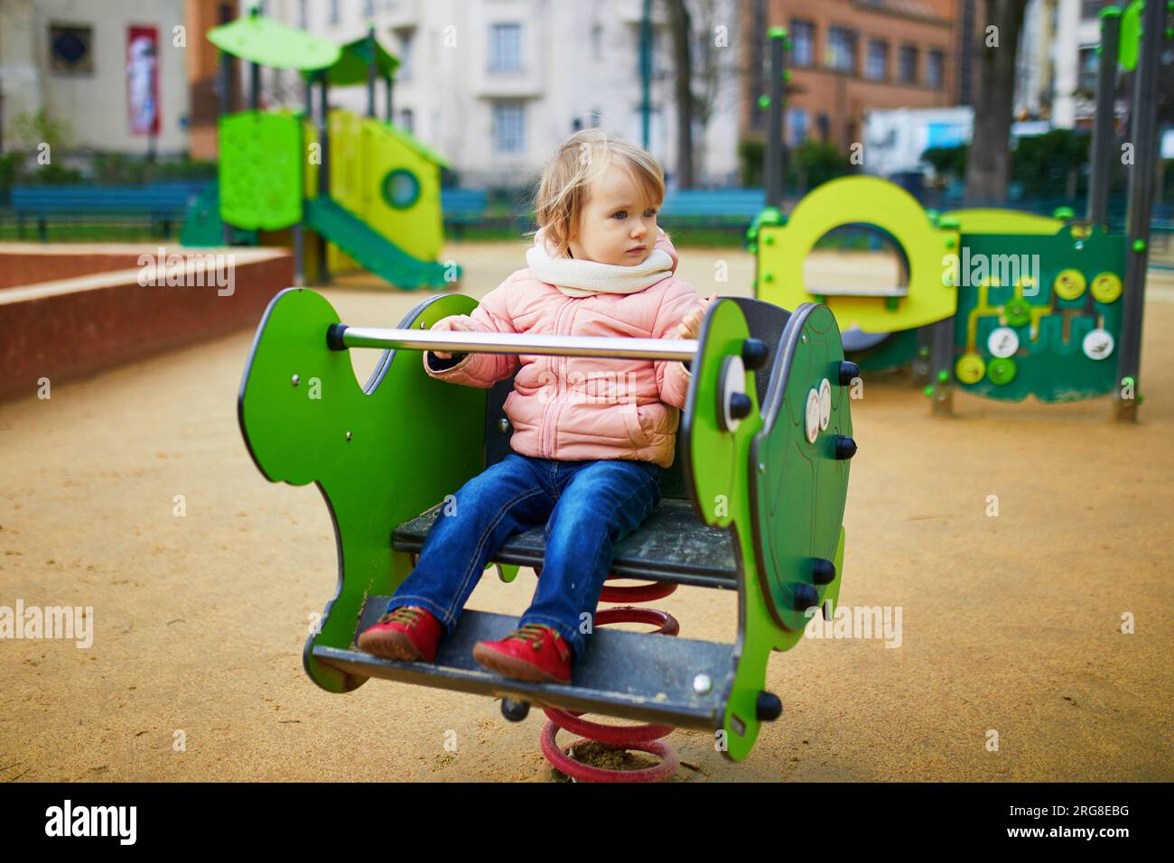 Baby Rider Outside Adorable toddler girl having fun on spring rider on playground. Outdoor ...
