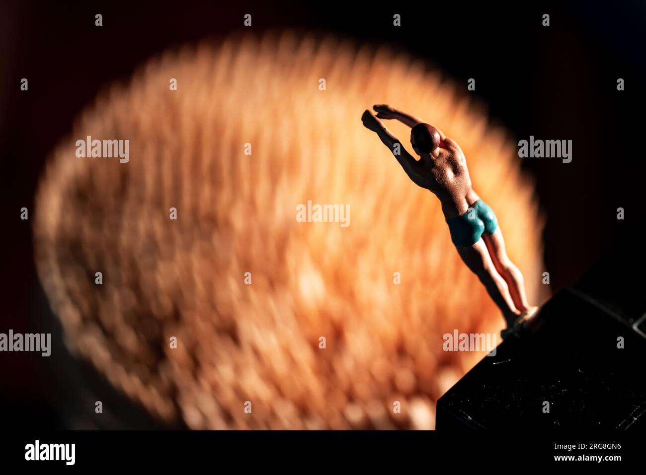 Miniature Olympic diver is ready to dive into a pool (made of out of focus toothpicks Stock Photo