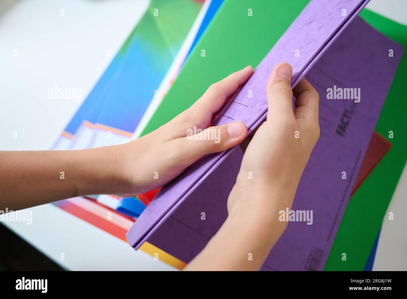 Berlin, Germany. 08th Aug, 2023. Symbolic image: A child holds a folder in his hands while new exercise books lie on a child's desk. The Federal Statistical Office has provided information on the price development of stationery, drawing materials and schoolbooks. Credit: Annette Riedl/dpa/Alamy Live News Stock Photo