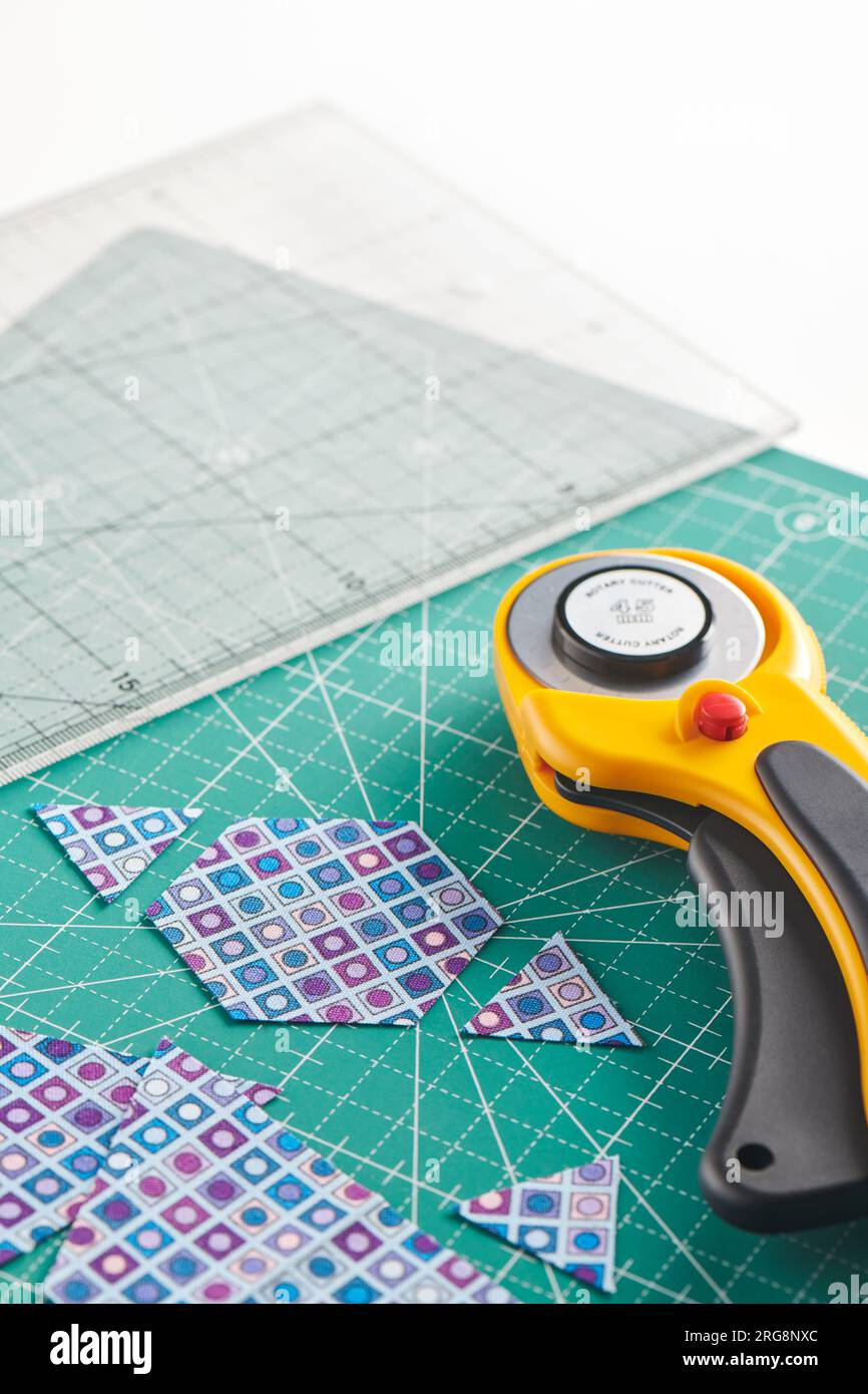 The process of cutting pieces of fabric in the shape of hexagons to create a quilt Stock Photo