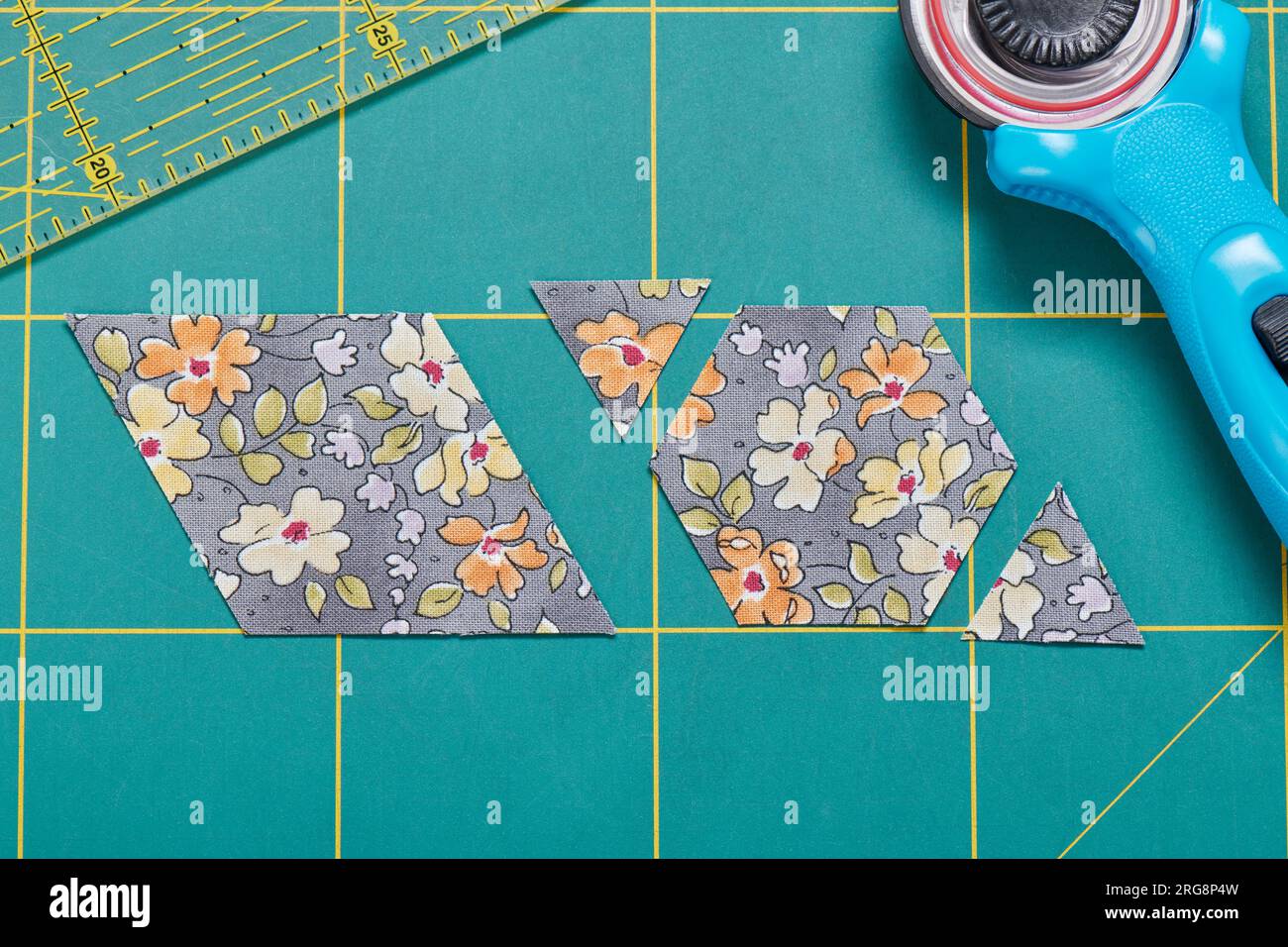 The process of cutting pieces of fabric in the shape of hexagons to create a quilt Stock Photo