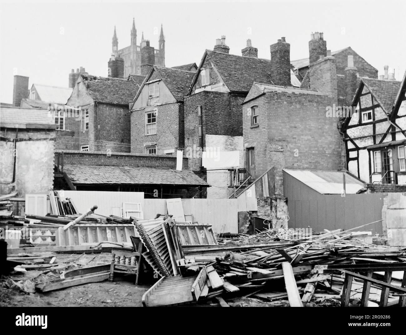 The rear of a row of old houses, as viewed through a demolition site