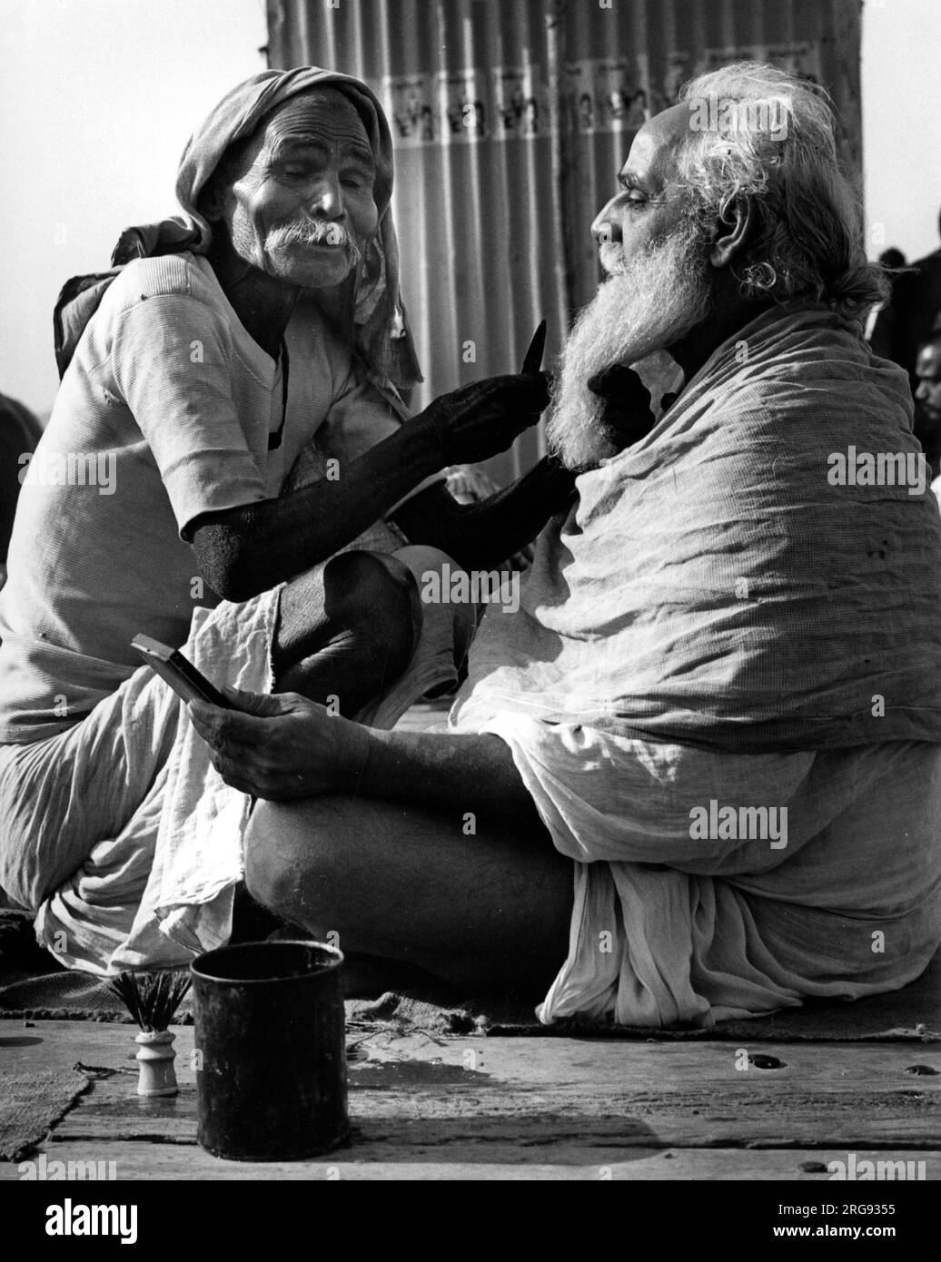 A Pilgrim In Benares India Visits A Blind Street Barber Before Taking An Early Morning Dip In