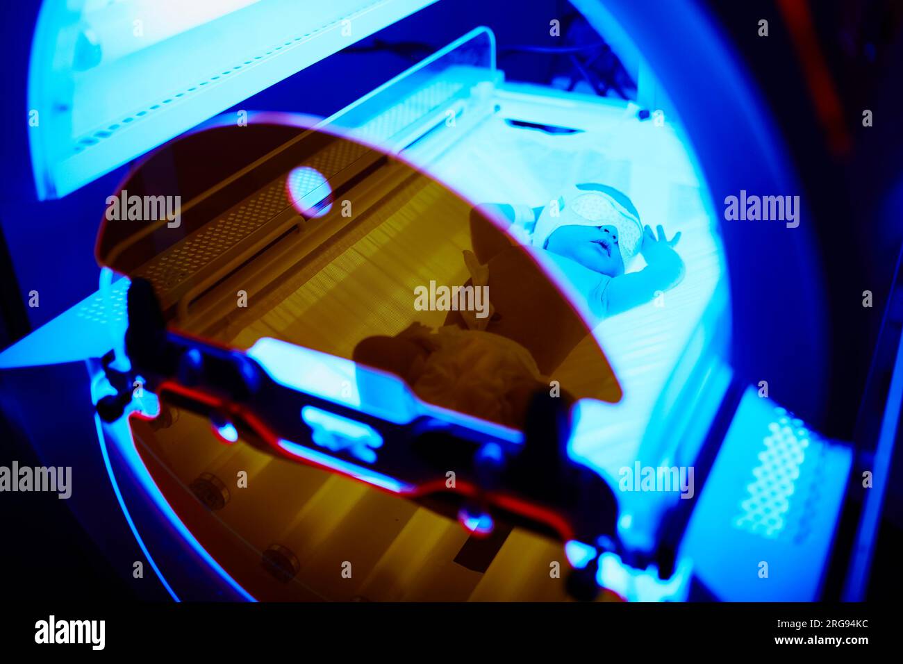 Newborn baby girl receiving phototherapy for jaundice at the maternity hospital Stock Photo