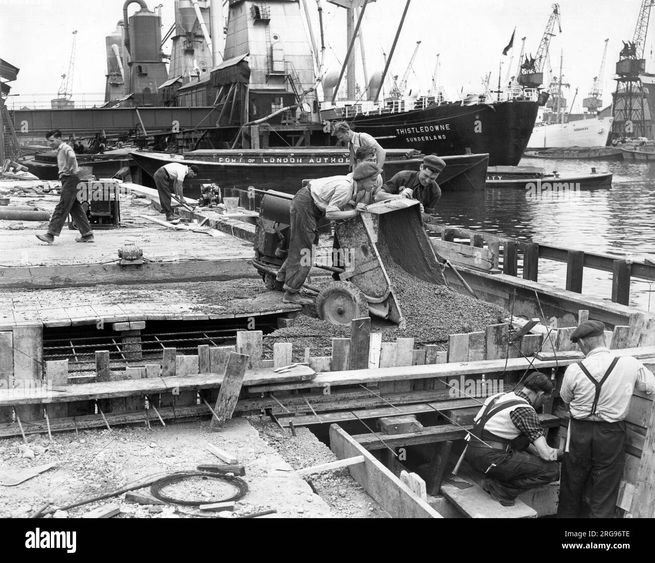 Dockside scene with vessels and men at work, River Thames, Port of London. Stock Photo