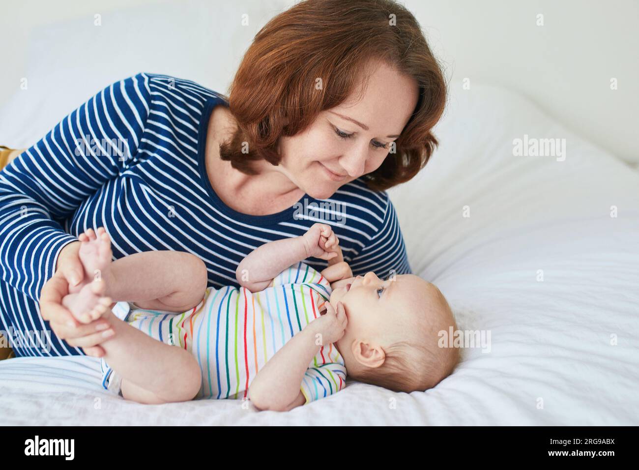 Mother and child in nursery. Mom and baby girl in bedroom. Parent and infant having time together and relaxing at home Stock Photo