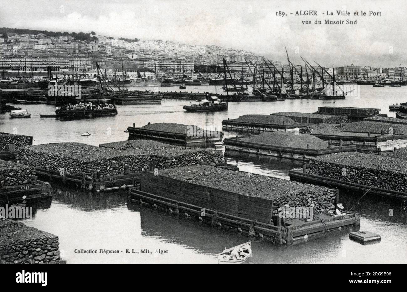 Algiers, Algeria Quarried stone on floating barges in the harbour, awaiting export. Date