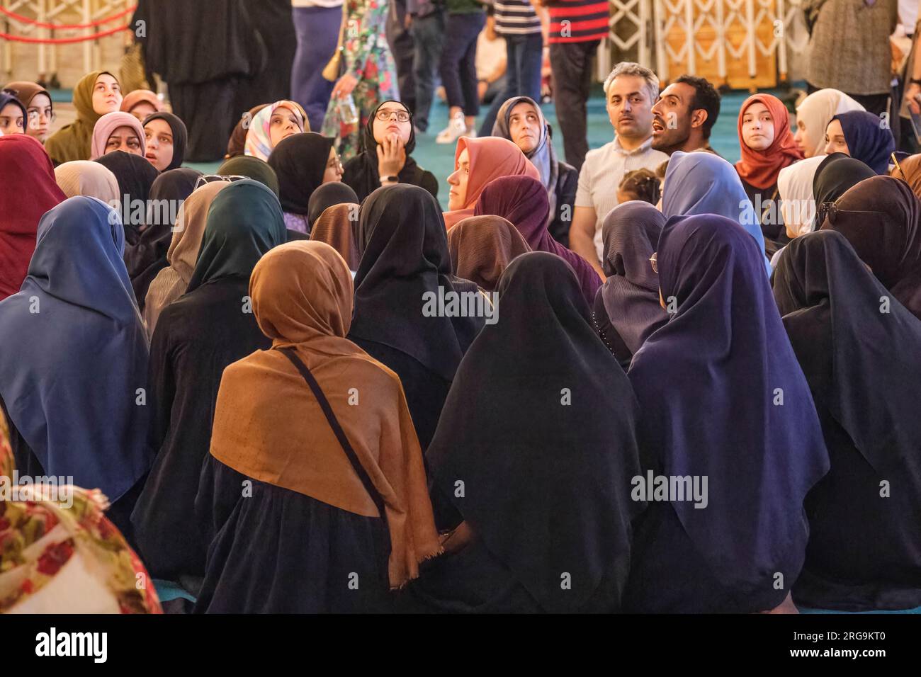 Istanbul, Turkey, Türkiye. Muslim Young Women Listening to Guide inside the Hagia Sophia Mosque. Stock Photo