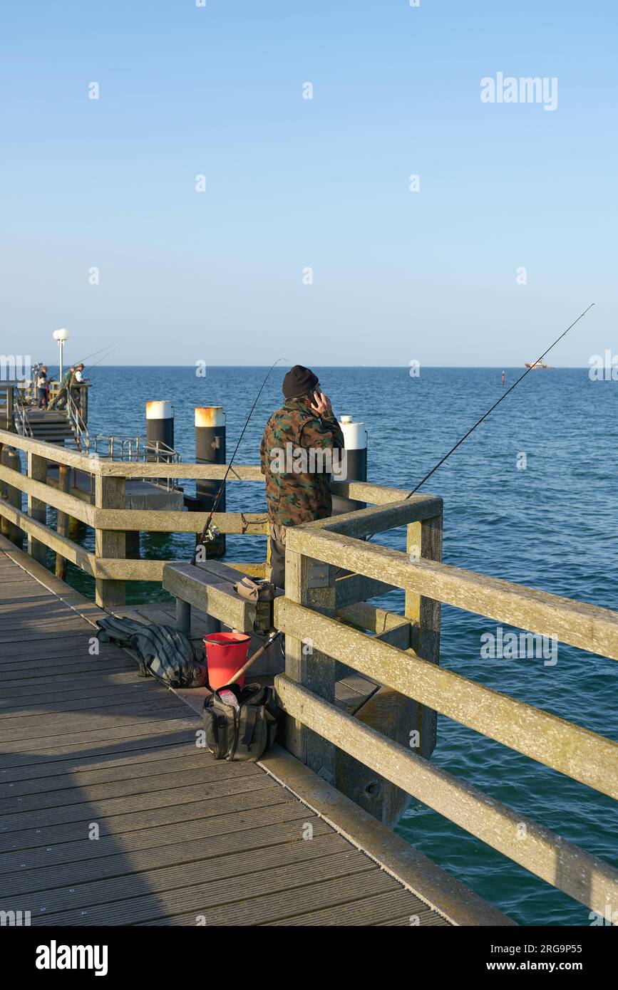 Fisherman on the pier of Kühlungsborn on the German Baltic Sea coast Stock Photo