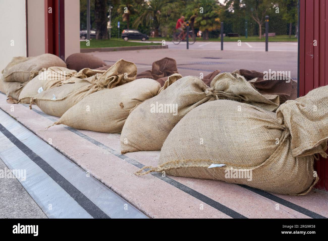 Sandbags as protection in front of the entrance to a hotel in Riva del Garda after a heavy storm in the region of Lake Garda in Italy Stock Photo