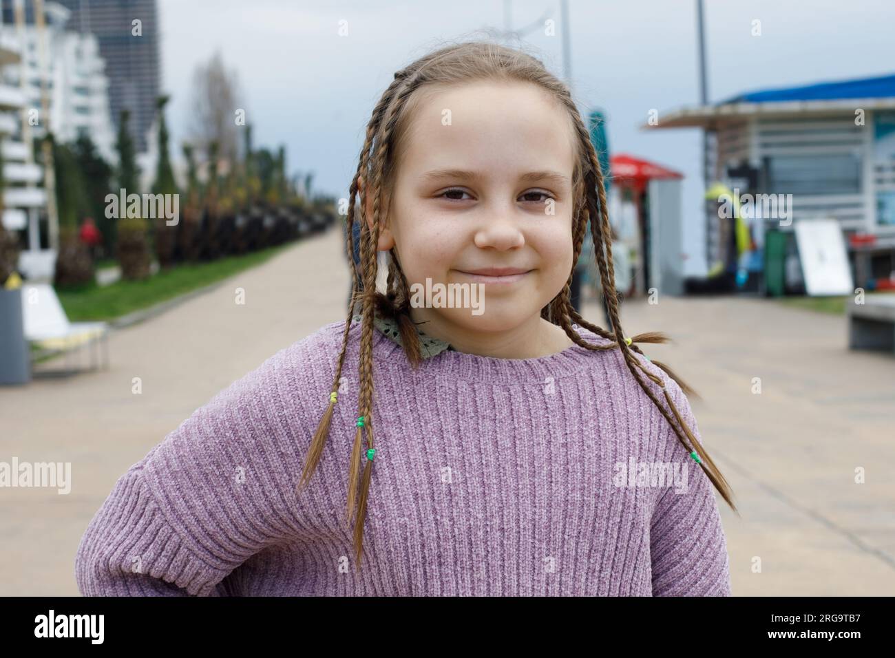 Cheerful kid girl with pigtails smiling, outdoor portrait Stock Photo
