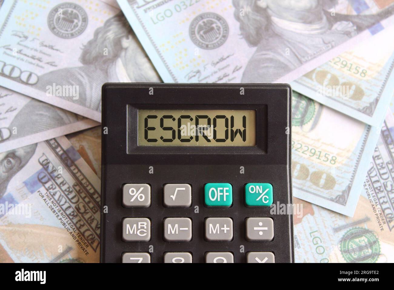 Top view image of money and calculator with text ESCROW on display. Finance concept. Stock Photo