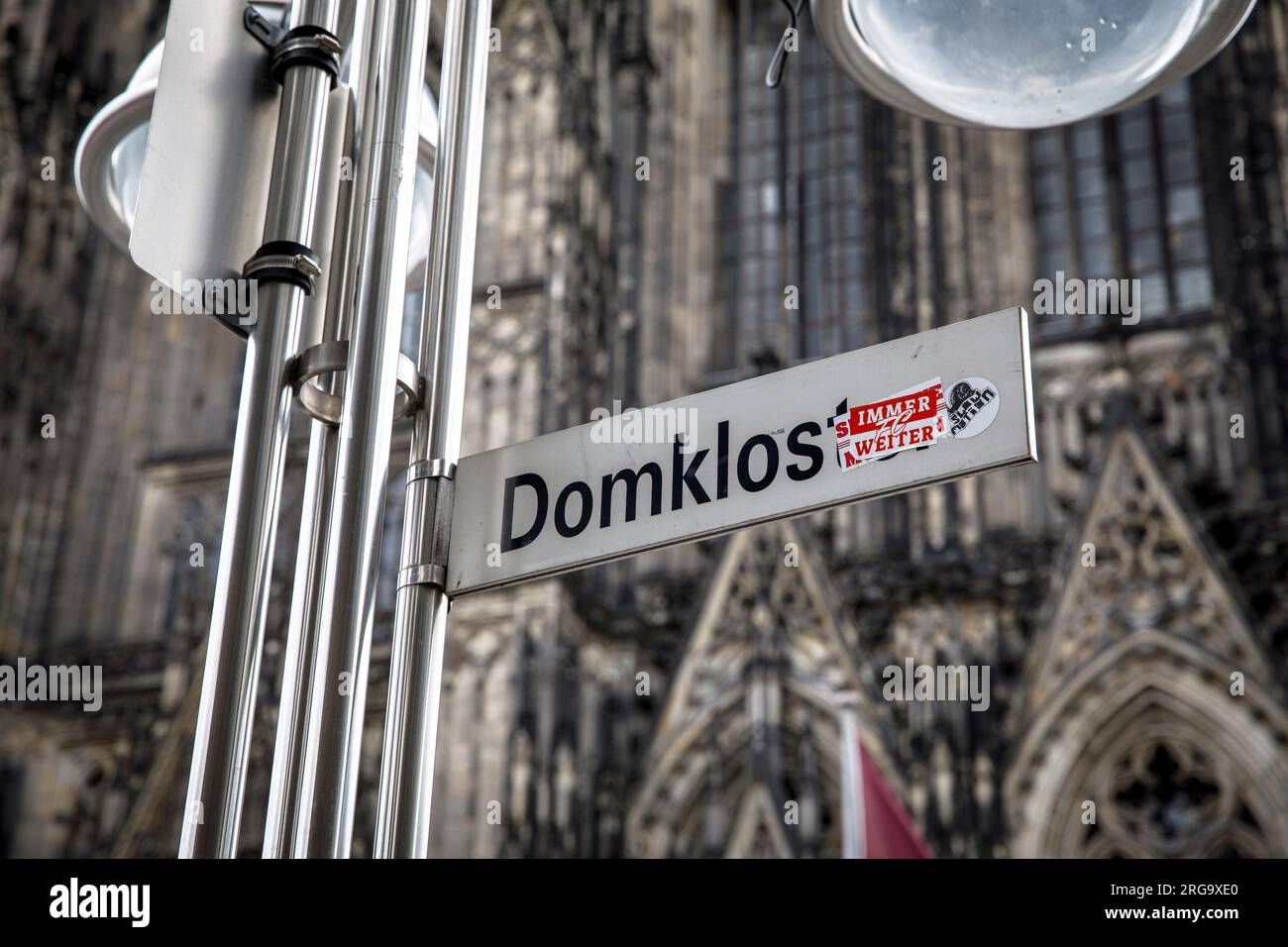street sign of  the street Domkloster (Cathedral Monastery) is renamed with a sticker to Domklos, which means cathedral toilet, Cologne, Germany. Stra Stock Photo