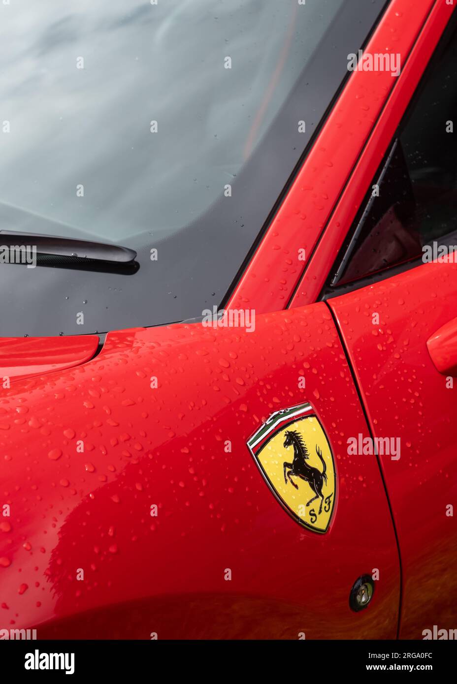 The Prancing Horse side panel logo and windscreen section of a red Ferrari F8 Tributo Italian sports car in portrait view. Stock Photo
