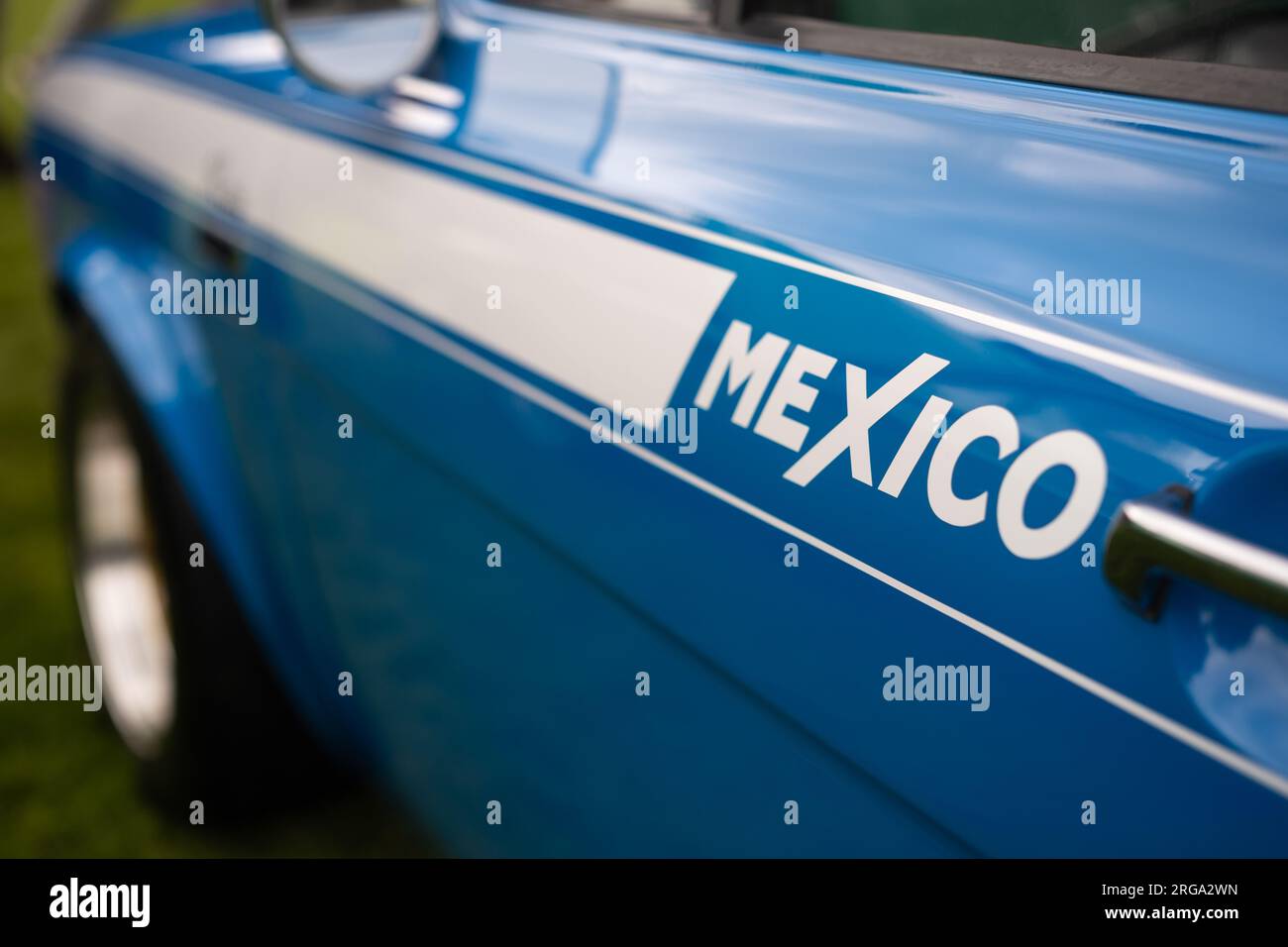 The left hand passenger side of a blue Mk1 Ford Escort Mexico vintage car showing the Mexico logo on the door. Stock Photo
