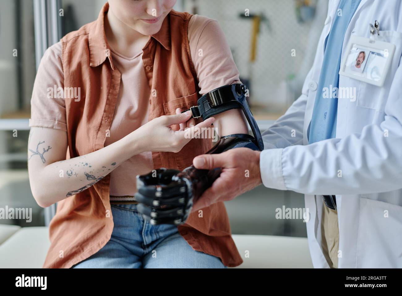 Closeup of doctor consulting young woman and fitting prosthetic arm in orthology clinic Stock Photo