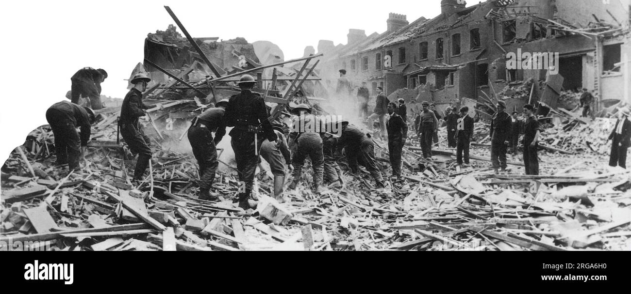Firefighters and volunteers help to clear wreckage following another night of air raids during the Blitz. Unidentified location. Stock Photo