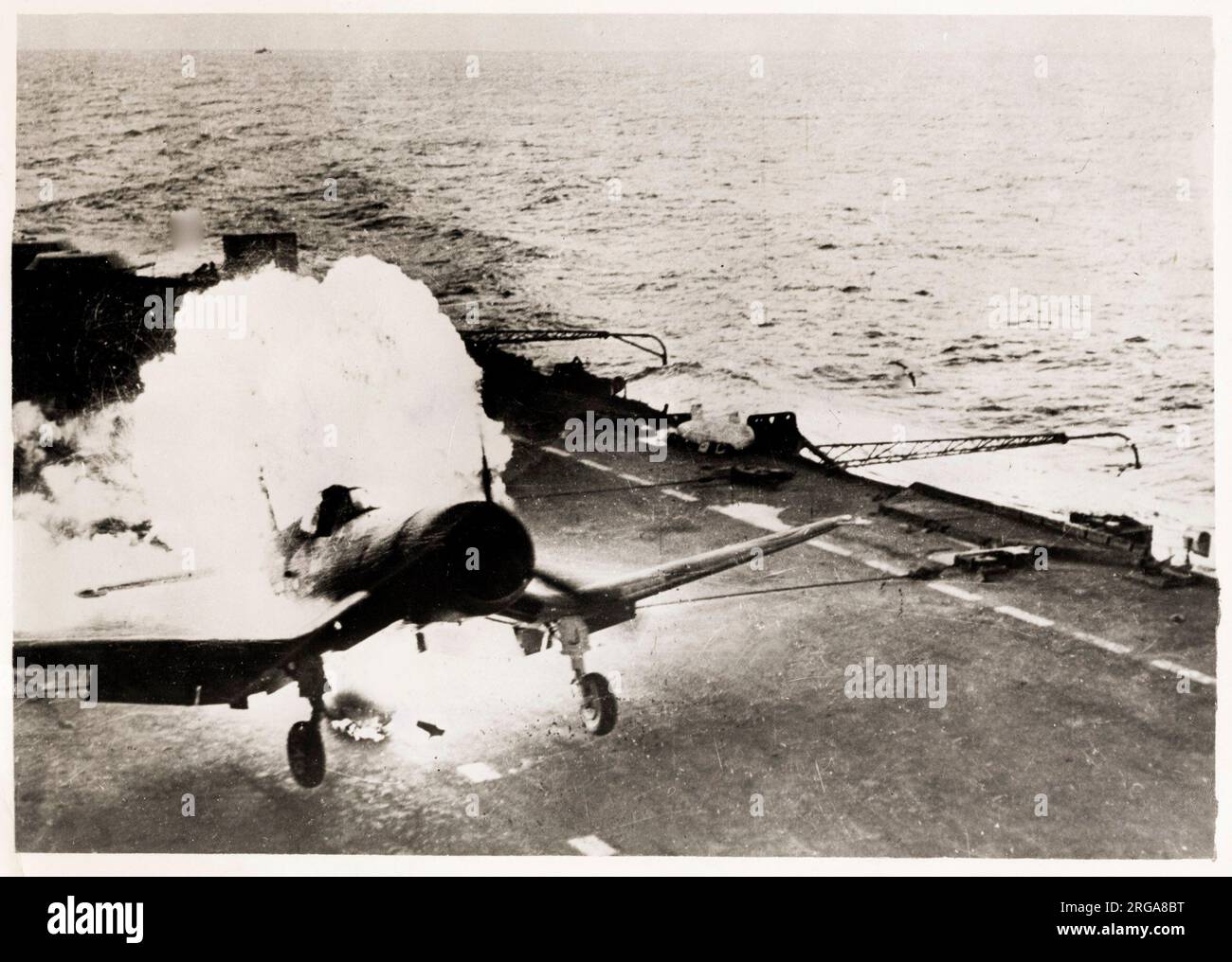 World War II -  Corsair lands in flames on aircraft carrier, Pacific Ocean, pilot unhurt Stock Photo