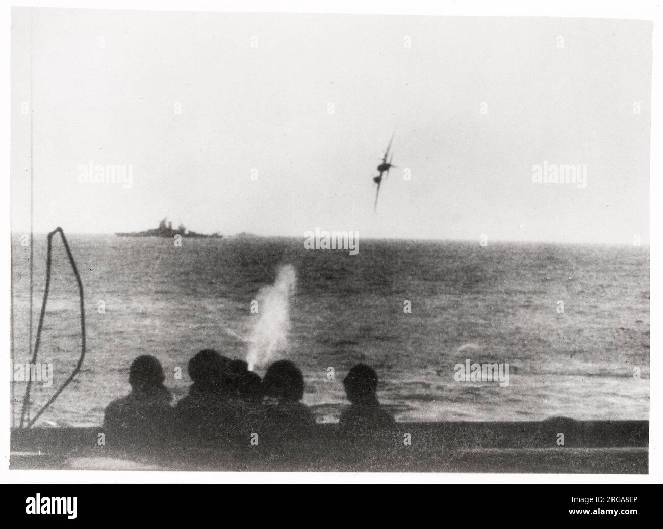 Vintage World War II photograph - Japanese suicide kamikaze attack on an American battleship in the Pacific. The plane was brought down just short of the ship. Stock Photo
