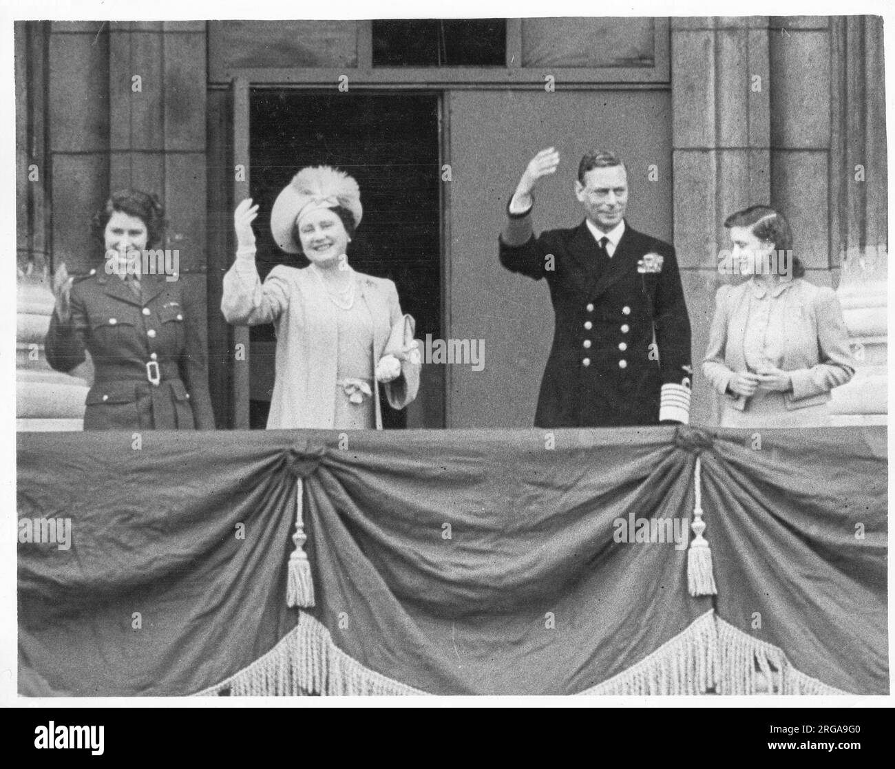 Vintage World War II photograph - the King, George VI of Great Britain accompanies by the Queen and Princesses Elizabeth and Margaret on the balcony of Buckingham Palace, VE Day celebration. Stock Photo