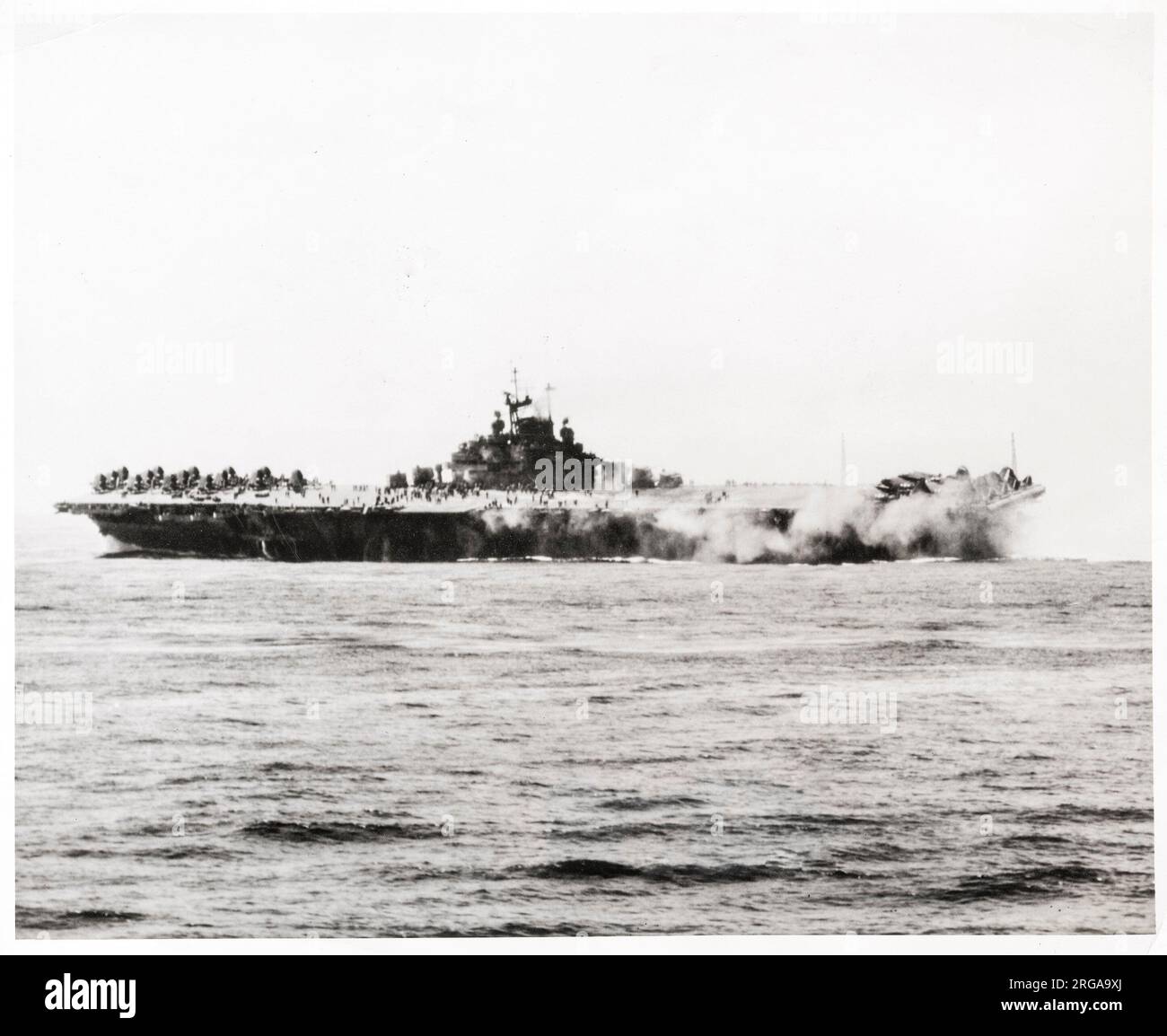 Vintage photograph World War II - US aircraft carrrier Intrepid after atttack by Japanese suicide kamikaze bomber Stock Photo