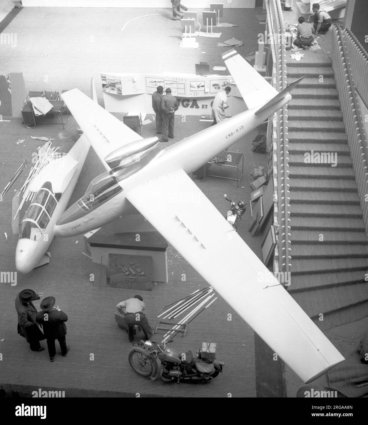 Fouga CM.8 R13 Cyclone at the XVIIIeme Salon Aeronautique du Paris 1949 at the Grand Palais in central Paris, (flying demonstrations were given at Orly Airport). The Turbomeca Pimene powered CM.8 R13 is hanging above the fuselage of a Fouga-Castel-Mauboussin CM.7 two-seat trainer. Stock Photo