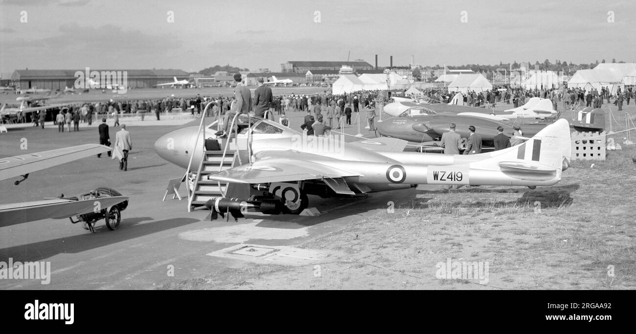 de Havilland DH.115 Vampire Trainer T.11 WZ419, the fourth production aircraft used for development, in the de Havilland line-up at the 1953 SBAC Farnborough Air Show. Also visible are the two Avro Vulcan prototypes and the first Handley Page Victor prototype on the other side of the runway where the de Havilland DH.110 WG240 is seen landing. de Havilland Canada DHC.1 Chipmunk T.10 WZ884 Sea Venom FAW.20 WM503 Venom FB.1 WE??? Vampire T.11 WZ419 Dove 6 G-AMZN, wing-tip visible to the left of WZ419 Stock Photo