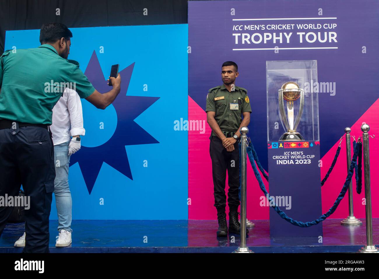 A security guard poses for a photo next to the ICC Men's Cricket World Cup trophy on display at the Sher-e-Bangla National Stadium in Mirpur, Dhaka. ICC Men's Cricket World Cup trophy tour in Bangladesh runs from 07 till 09 August 2023. (Photo by Sazzad Hossain / SOPA Images/Sipa USA) Stock Photo