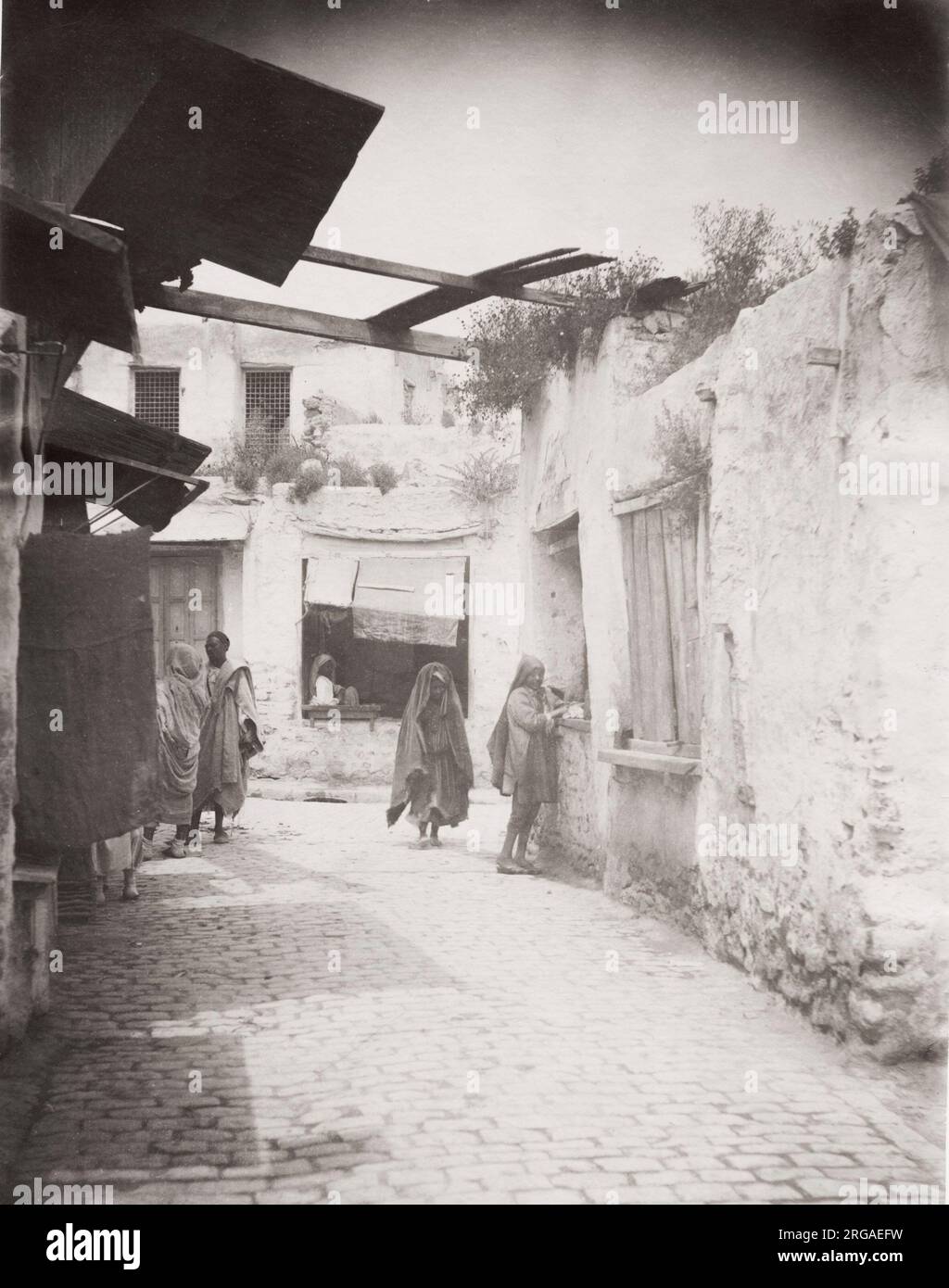 Vintage 19th century photograph: back street in Tunis, Tunisia, people and architecture. Stock Photo