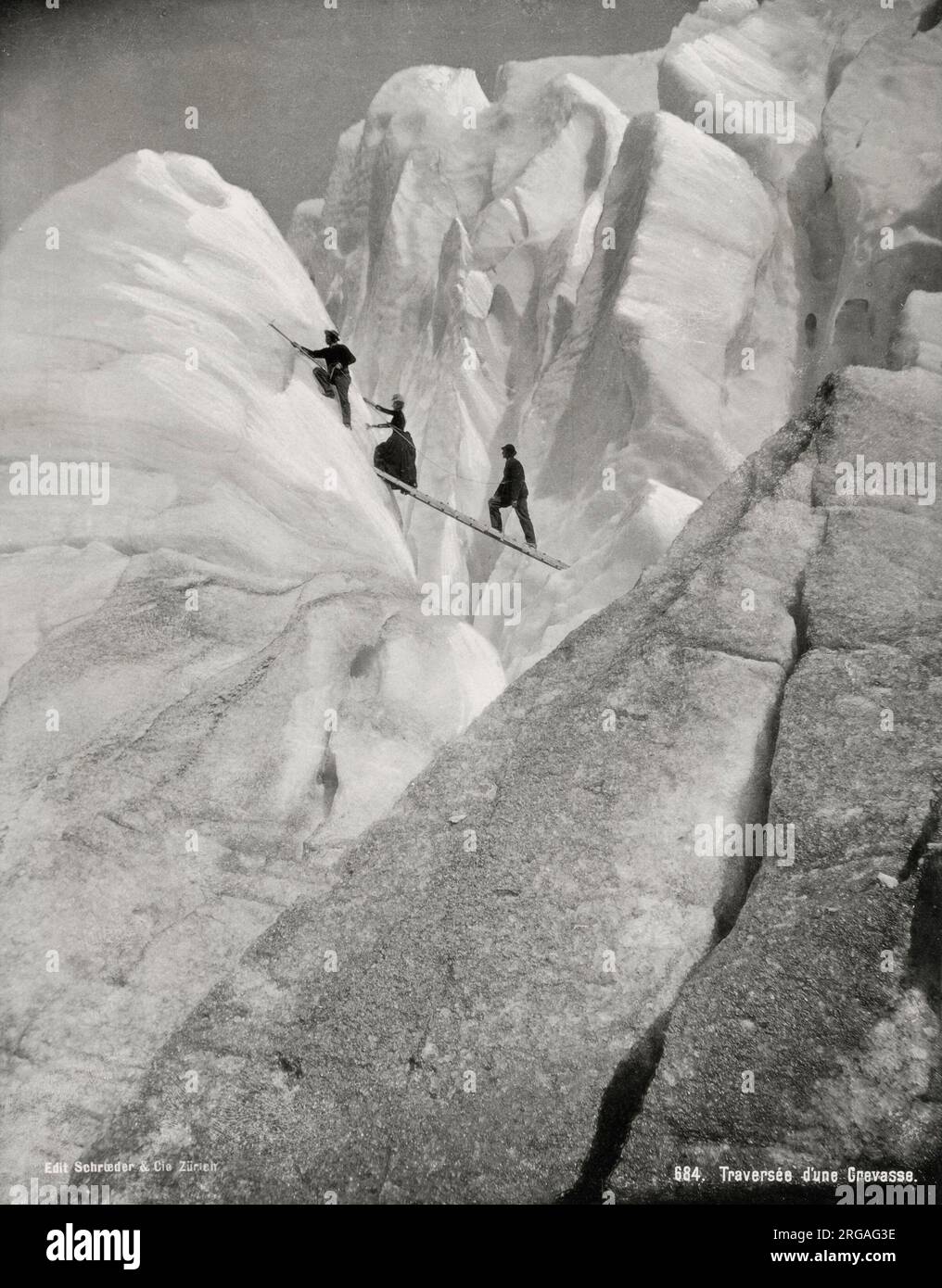 Vintage 19th century photograph - traversing a crevasse, climbers in the  Alps. Stock Photo