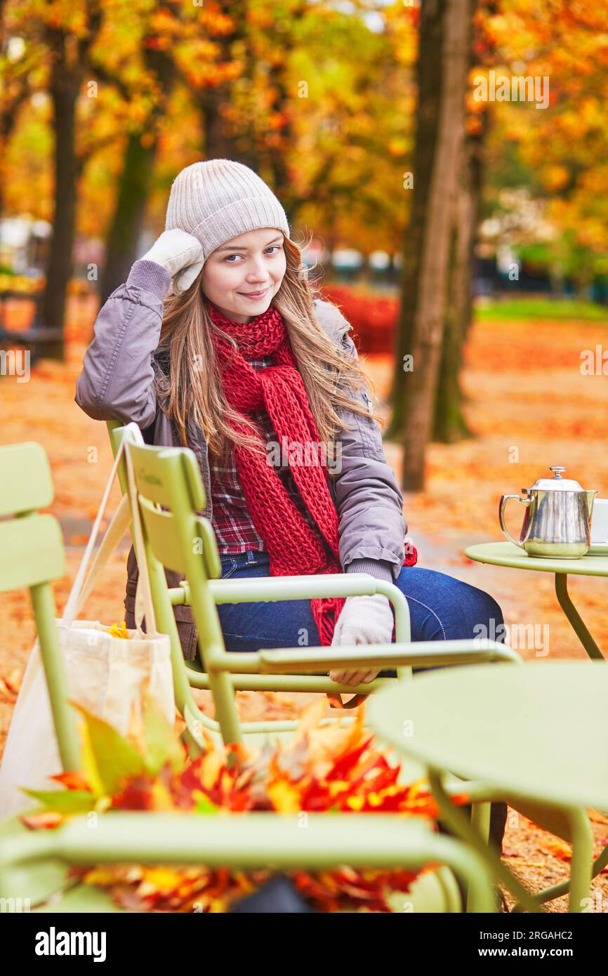 Girl in an outdoor cafe on a bright fall day in Paris Stock Photo