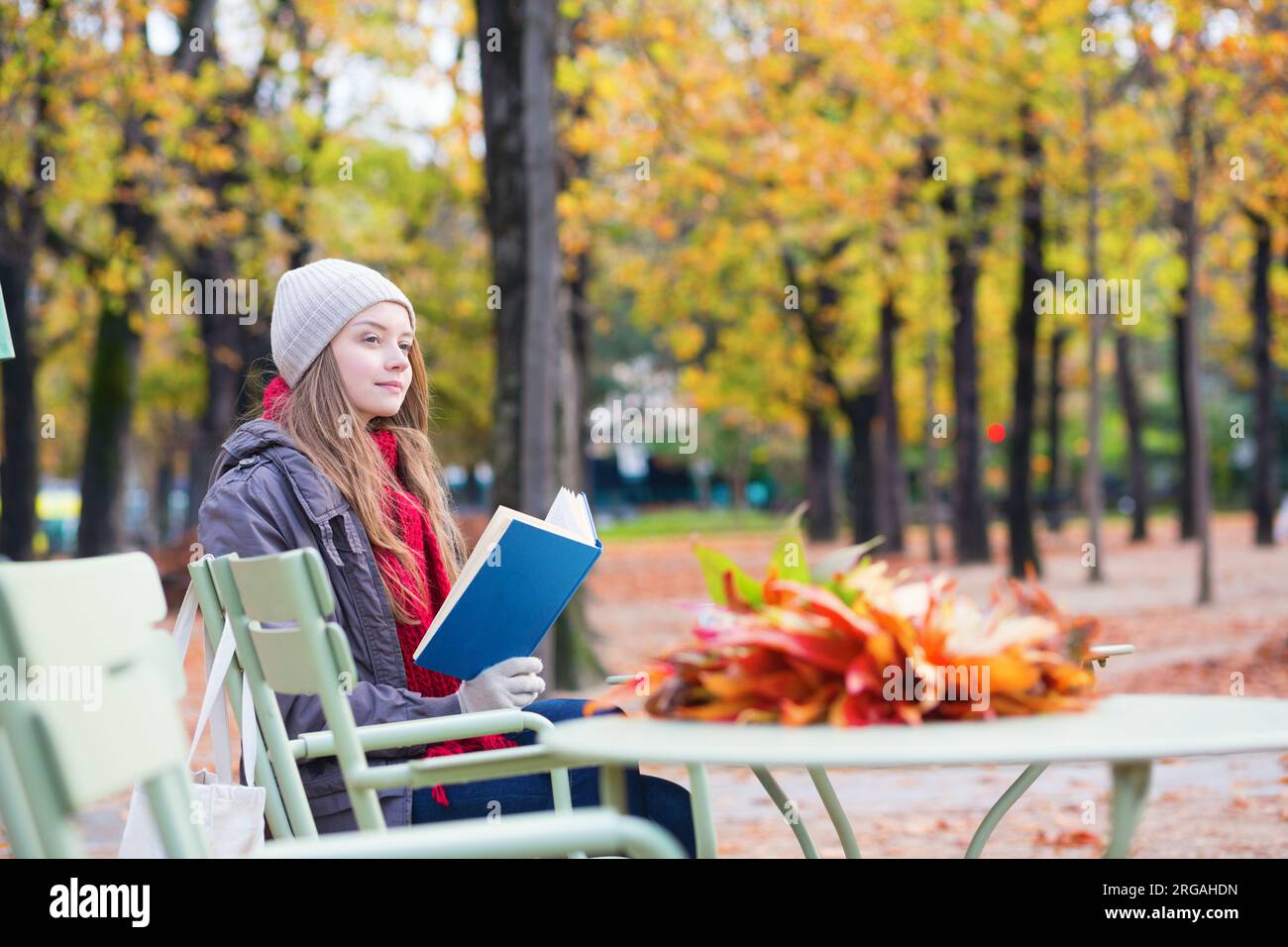 Girl reading a book in an outdoor cafe in Paris Stock Photo