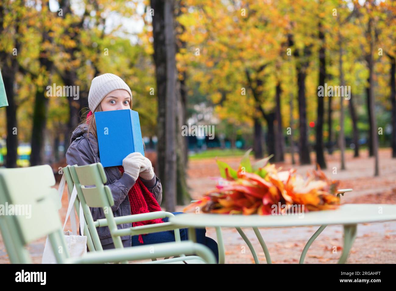 Girl reading a book in an outdoor cafe in Paris Stock Photo