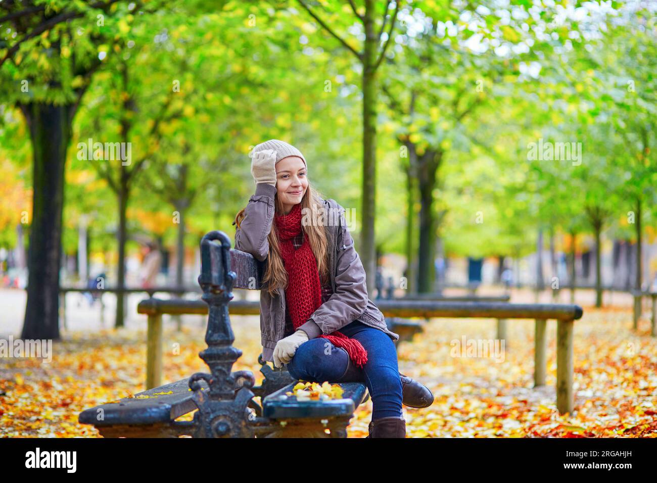 Young girl sitting on a bench in park on a fall day Stock Photo - Alamy