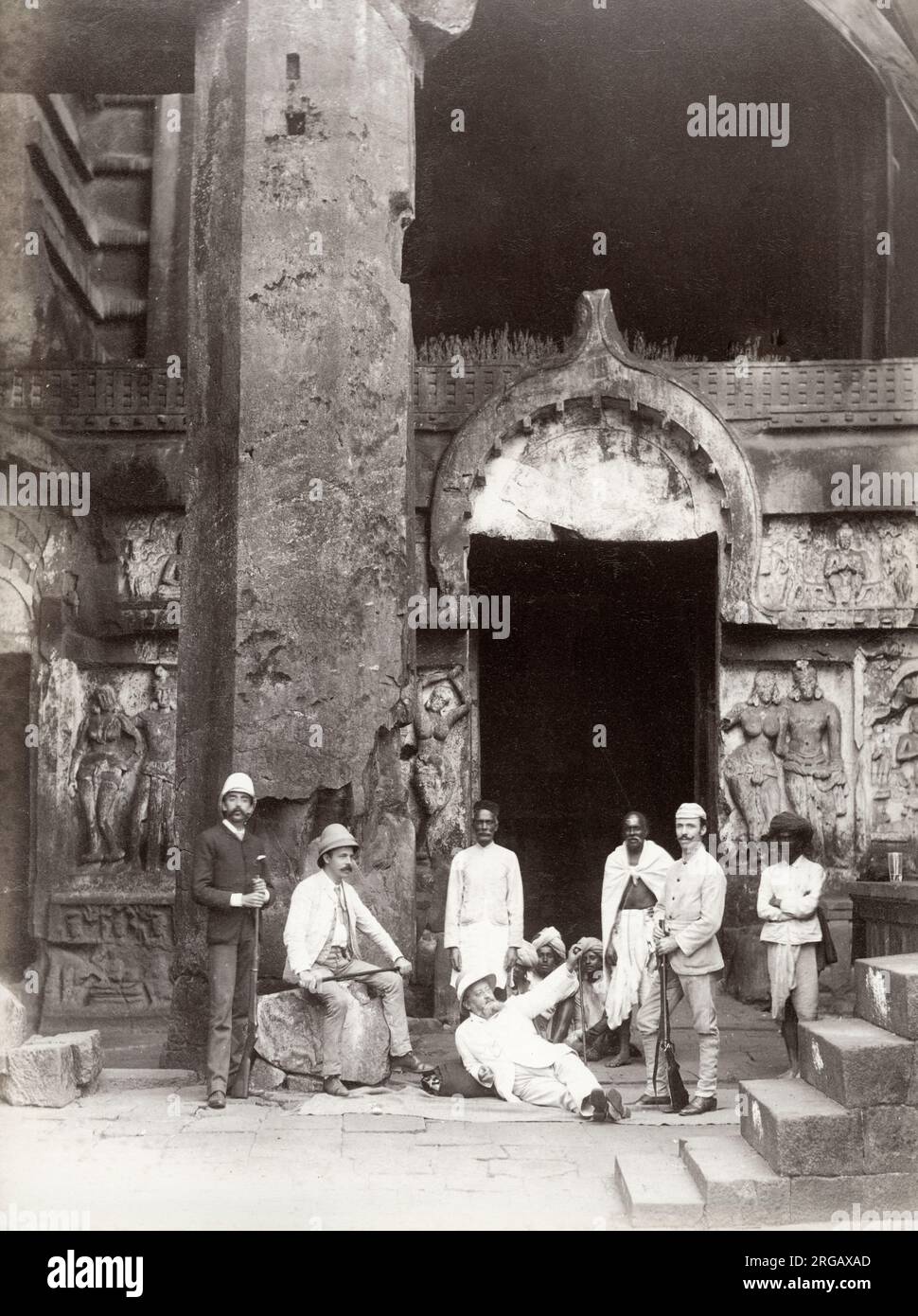 Vintage 19th century photograph: westerners and native Indian men at a temple entrance, India, c.1880s. Stock Photo