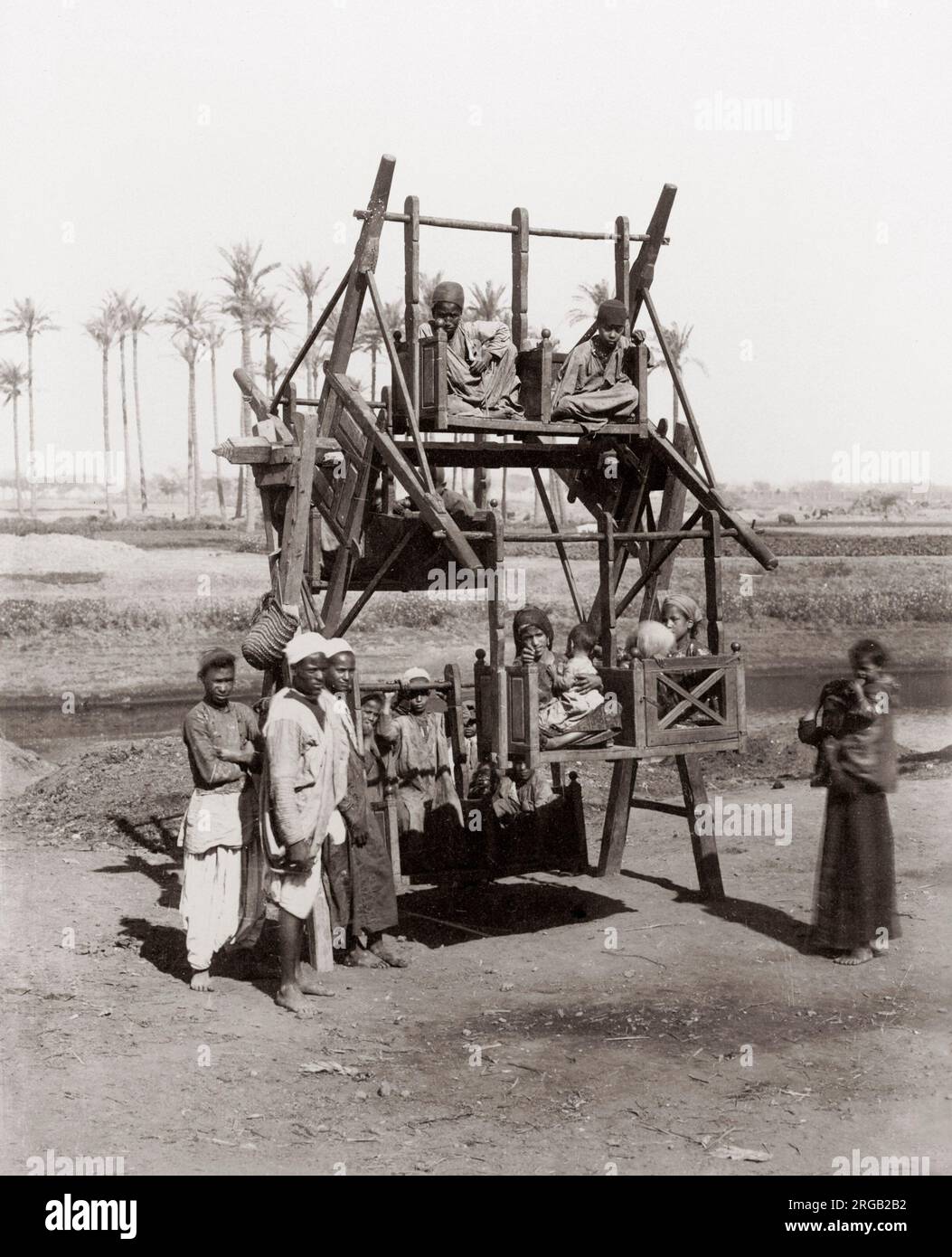 Children on an early funfair ride, Egypt, c.1890 Stock Photo
