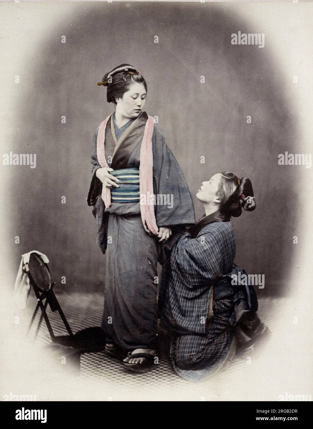 1860's Japan - portrait of a young woman tying her obi sash Felice or Felix Beato (1832 - 29 January 1909),  Italian-British photographer working mostly in India, Japan, China Stock Photo