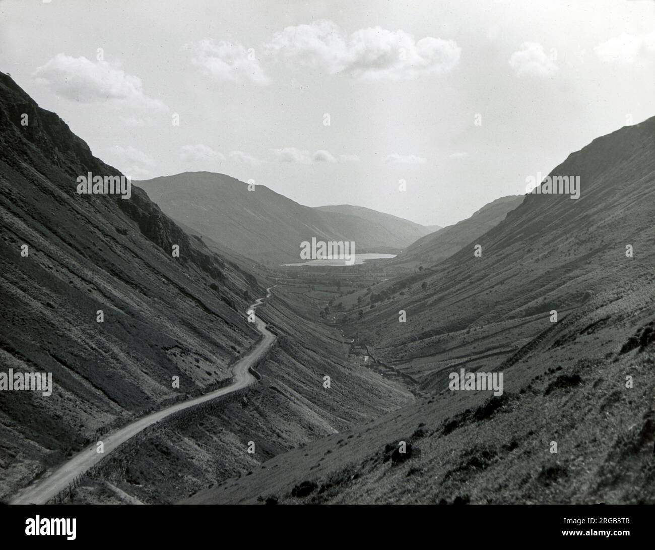 Road running through a steep-sided valley, Snowdonia National Park, North Wales. Stock Photo